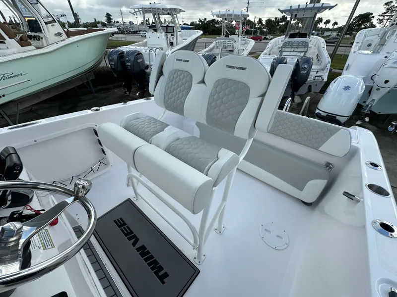Slide: The Image of 2025 Twin Vee 240 GFX CC boat interior with dual seating and steering wheel. - 11