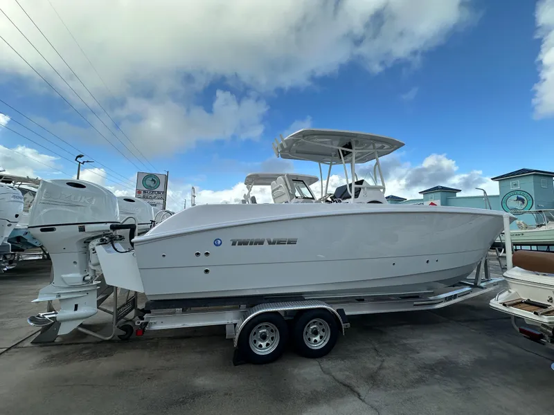 Slide: The Image of 2025 Twin Vee 240 GFX CC boat on trailer under cloudy sky. - 2