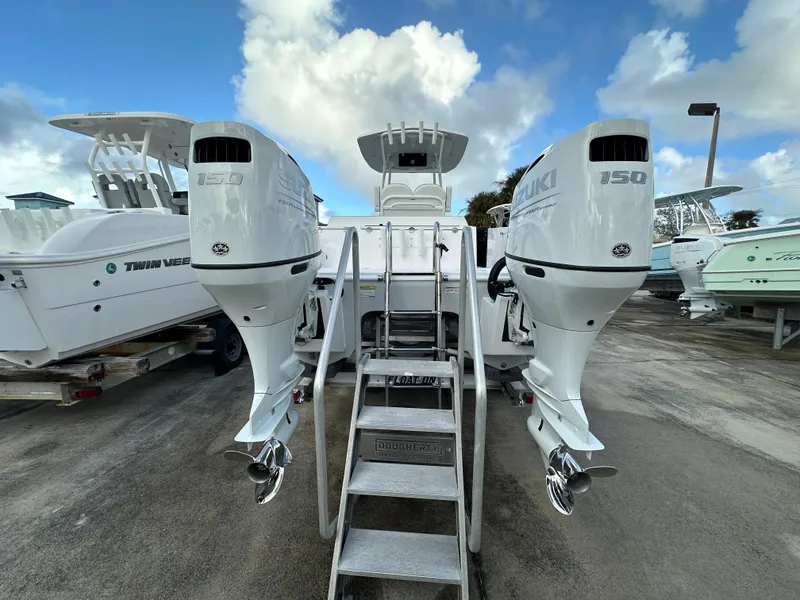 Slide: The Image of 2025 Twin Vee 240 GFX CC boat with dual outboard engines, docked under a cloudy sky. - 3