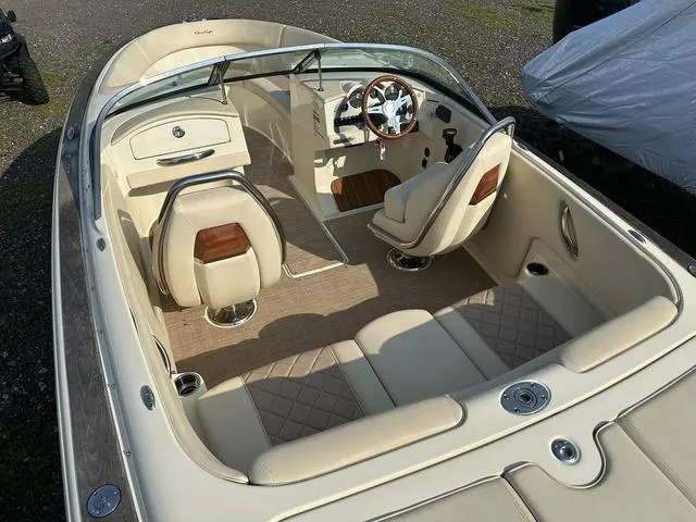 Slide: The Image of 2018 Chris-Craft Launch 23 boat interior with beige seating and wooden accents. - 10