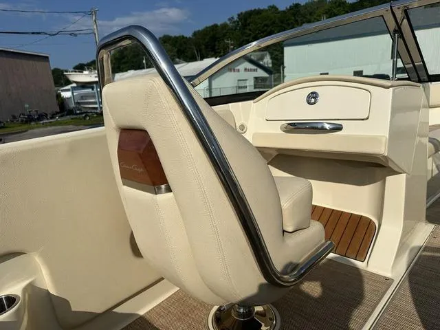 Slide: The Image of 2018 Chris-Craft Launch 23 boat interior with beige seating and polished metal accents. - 12