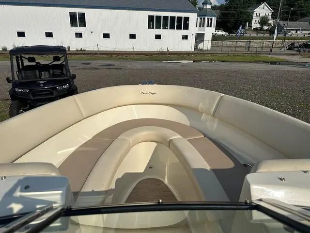Slide: The Image of 2018 Chris-Craft Launch 23 boat interior with beige seating, parked near a building. - 14