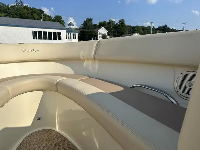 Slide: The Image of 2018 Chris-Craft Launch 23 boat interior with beige seating and speaker, under clear blue sky. - 16