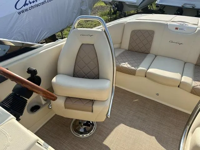 Slide: The Image of 2018 Chris-Craft Launch 23 boat interior with beige leather seating and wooden steering wheel. - 21