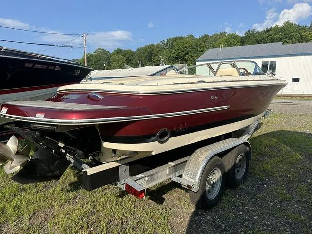 Slide: The Image of 2018 Chris-Craft Launch 23 boat on trailer, maroon and cream, parked outdoors. - 3