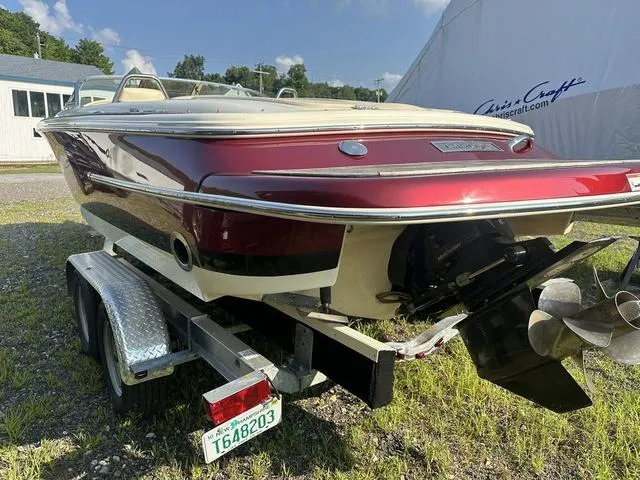 Slide: The Image of 2018 Chris-Craft Launch 23 boat on trailer, red and white exterior, parked outdoors. - 4