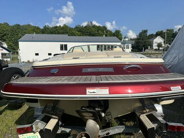 Slide: The Image of 2018 Chris-Craft Launch 23 boat with red exterior, parked on a trailer outdoors. - 7