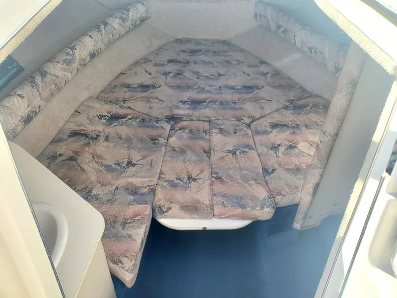 Slide: The Image of 1996 Sea Ray 215 Express Cruiser cabin interior with patterned cushions. - 10
