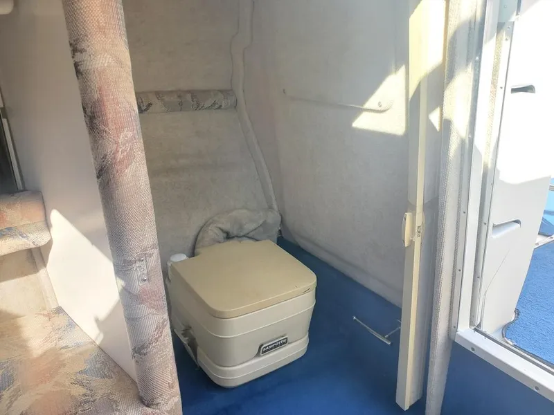Slide: The Image of Interior of 1996 Sea Ray 215 Express Cruiser with portable toilet. - 11