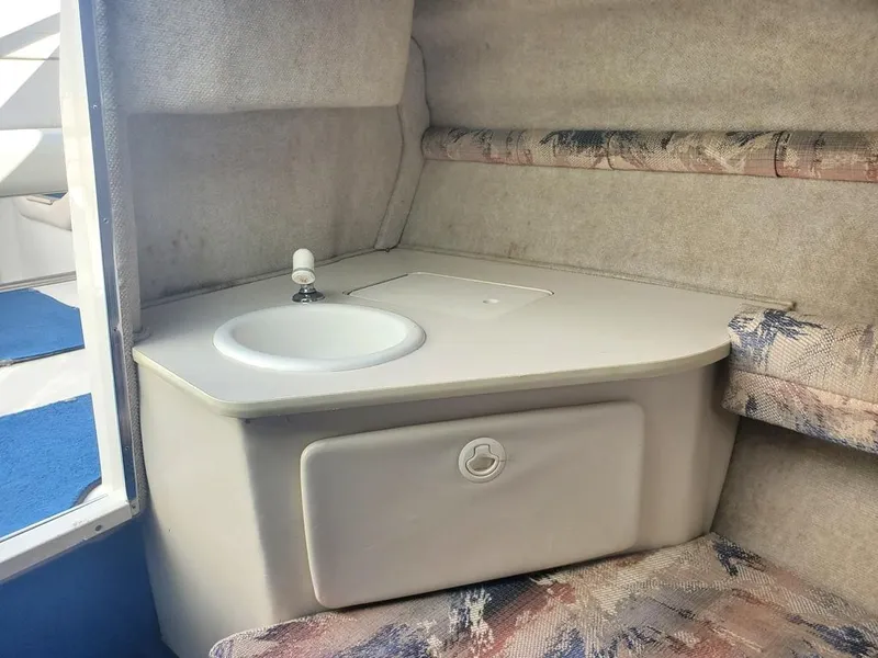 Slide: The Image of 1996 Sea Ray 215 Express Cruiser cabin interior with sink and storage. - 13