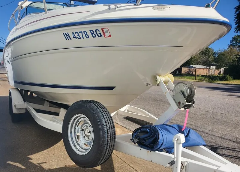 Slide: The Image of 1996 Sea Ray 215 Express Cruiser on trailer, parked outdoors. - 15