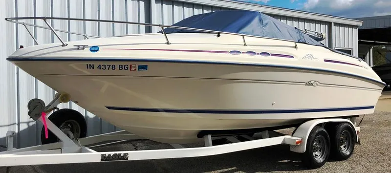 Slide: The Image of 1996 Sea Ray 215 Express Cruiser on trailer, parked outdoors. - 27