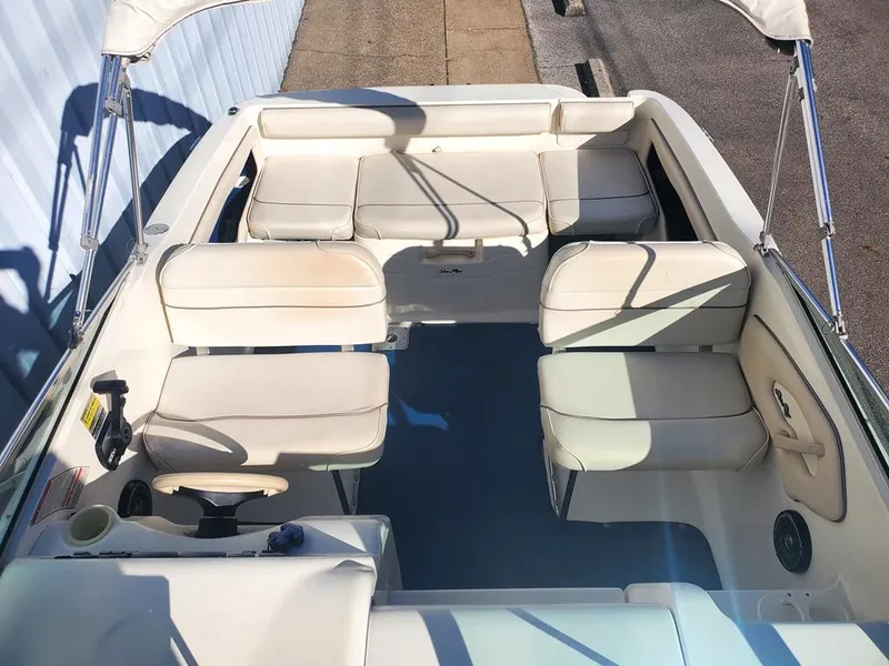 Slide: The Image of 1996 Sea Ray 215 Express Cruiser interior with white seating and blue flooring. - 4