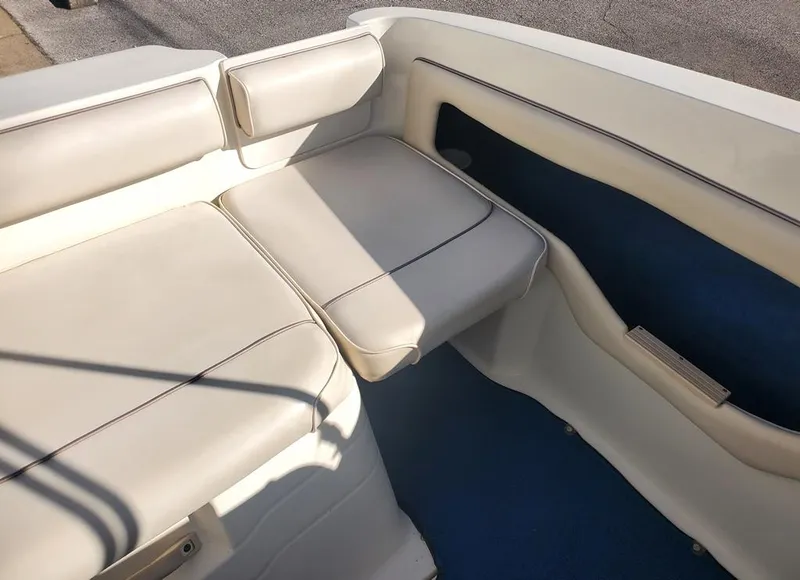Slide: The Image of 1996 Sea Ray 215 Express Cruiser interior seating with white upholstery. - 5