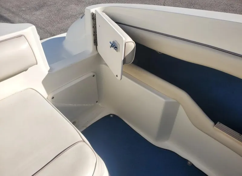 Slide: The Image of 1996 Sea Ray 215 Express Cruiser interior seating area with storage compartment. - 6