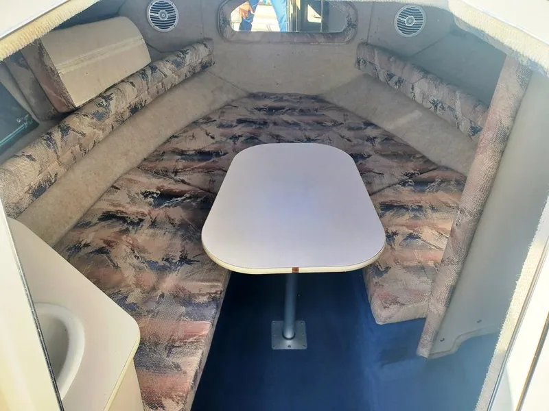 Slide: The Image of 1996 Sea Ray 215 Express Cruiser cabin interior with seating and table. - 9