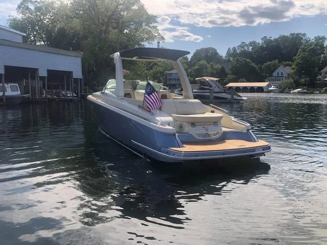 Slide: The Image of 2022 Chris-Craft Launch 28 GT boat on a serene lake with American flag. - 4