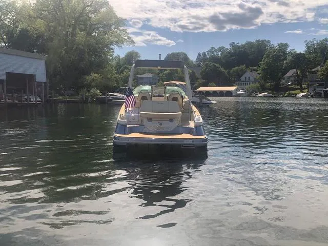 Slide: The Image of 2022 Chris-Craft Launch 28 GT boat on a serene lake with American flag. - 6