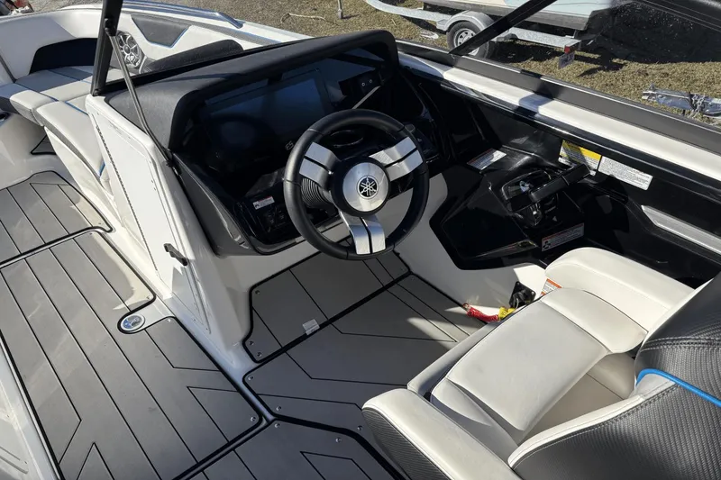 Slide: The Image of 2021 Yamaha Boats 212XE cockpit with steering wheel and seating, showcasing modern design. - 10