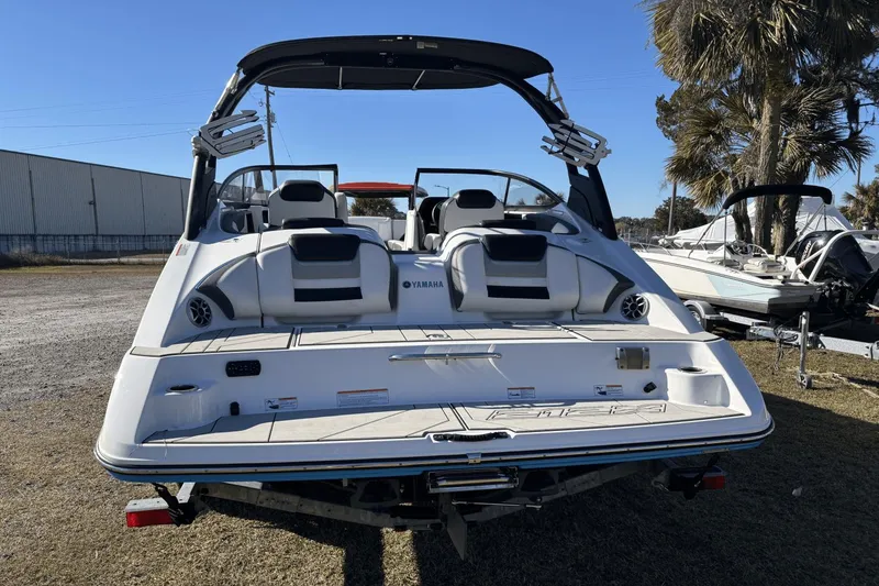 Slide: The Image of 2021 Yamaha Boats 212XE, rear view, parked outdoors, showcasing seating and design features. - 3