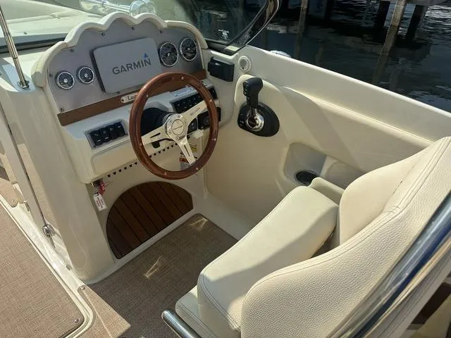 Slide: The Image of 2021 Chris-Craft Launch 27 cockpit with Garmin navigation and wooden steering wheel. - 13