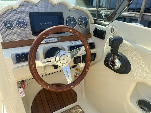 Slide: The Image of 2021 Chris-Craft Launch 27 dashboard with Garmin display and wooden steering wheel. - 14