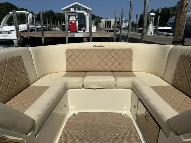 Slide: The Image of 2021 Chris-Craft Launch 27 boat interior with beige quilted seating at a marina. - 21