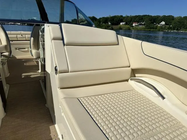 Slide: The Image of 2021 Chris-Craft Launch 31 GT boat interior with beige seating by the water. - 19