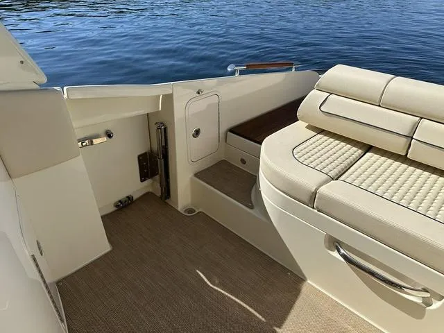 Slide: The Image of 2021 Chris-Craft Launch 31 GT interior with beige seating and water view. - 23