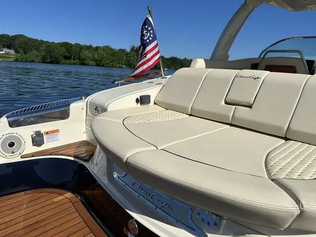 Slide: The Image of 2021 Chris-Craft Launch 31 GT boat with luxurious seating and American flag on a sunny lake. - 4
