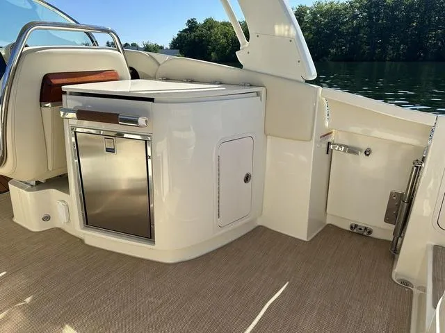 Slide: The Image of 2021 Chris-Craft Launch 31 GT interior with sleek kitchenette and stainless steel fridge. - 8