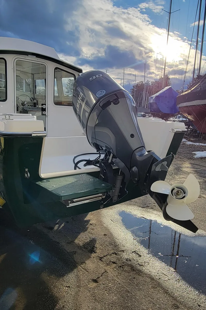 Slide: The Image of 2025 C-Dory 22' Cruiser with outboard motor in a sunny marina. - 3