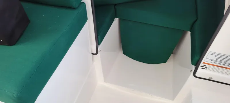 Slide: The Image of Interior seating of 2025 C-Dory 22' Cruiser with green cushions. - 7