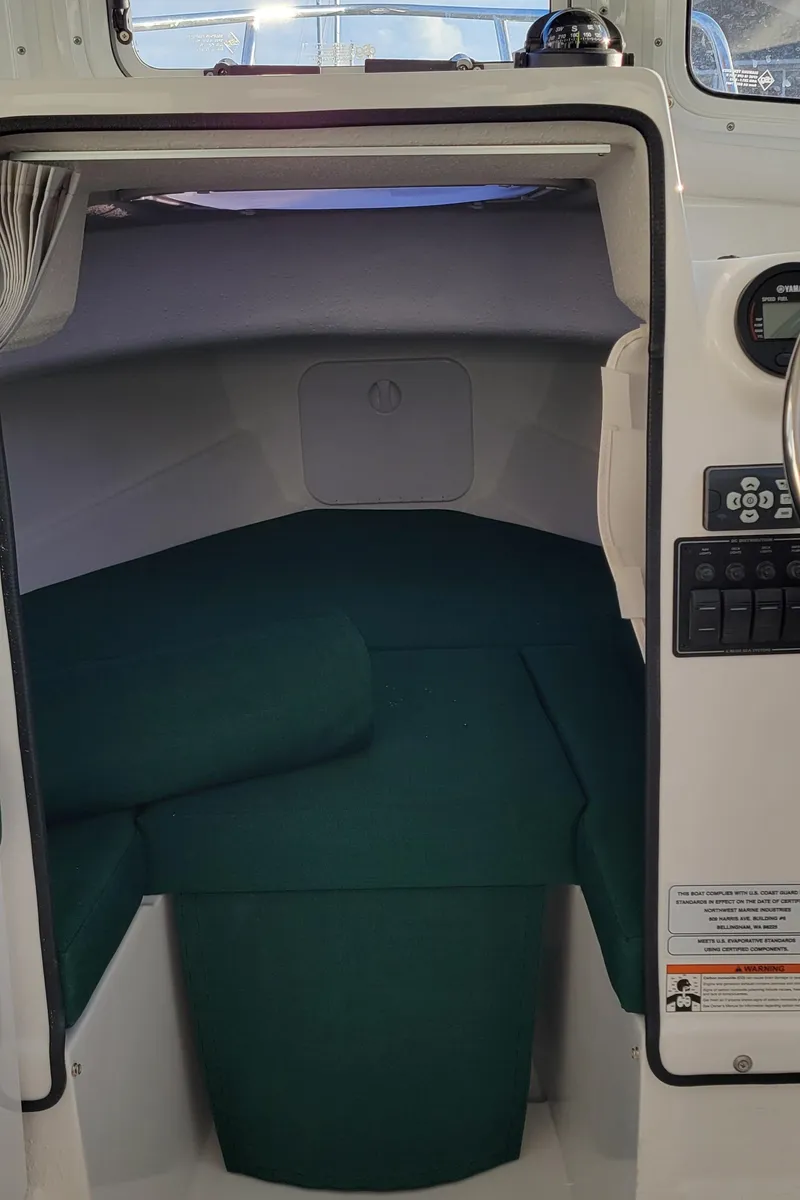 Slide: The Image of 2025 C-Dory 22' Cruiser cabin interior with green cushions. - 8