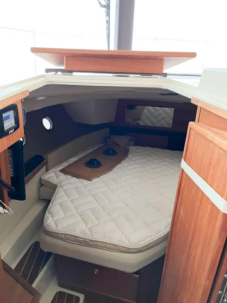 Slide: The Image of 2020 Ranger Tugs R-29 CB cabin interior with cozy bed and wooden accents. - 12