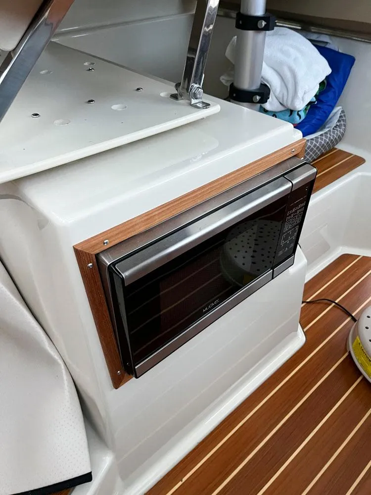 Slide: The Image of 2020 Ranger Tugs R-29 CB interior with microwave and wooden flooring. - 13