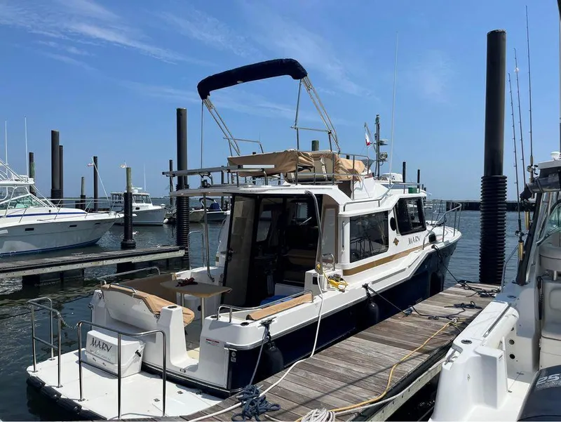 Slide: The Image of 2020 Ranger Tugs R-29 CB docked at marina under clear blue sky. - 2