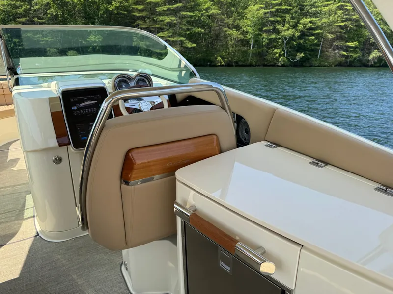 Slide: The Image of 2021 Chris-Craft Launch 35 GT interior with steering wheel and dashboard, on a serene lake. - 10