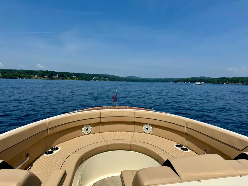 Slide: The Image of 2021 Chris-Craft Launch 35 GT boat on a serene lake under a clear blue sky. - 15
