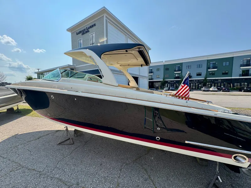 Slide: The Image of 2021 Chris-Craft Launch 35 GT boat with American flag, parked at a marina. - 28