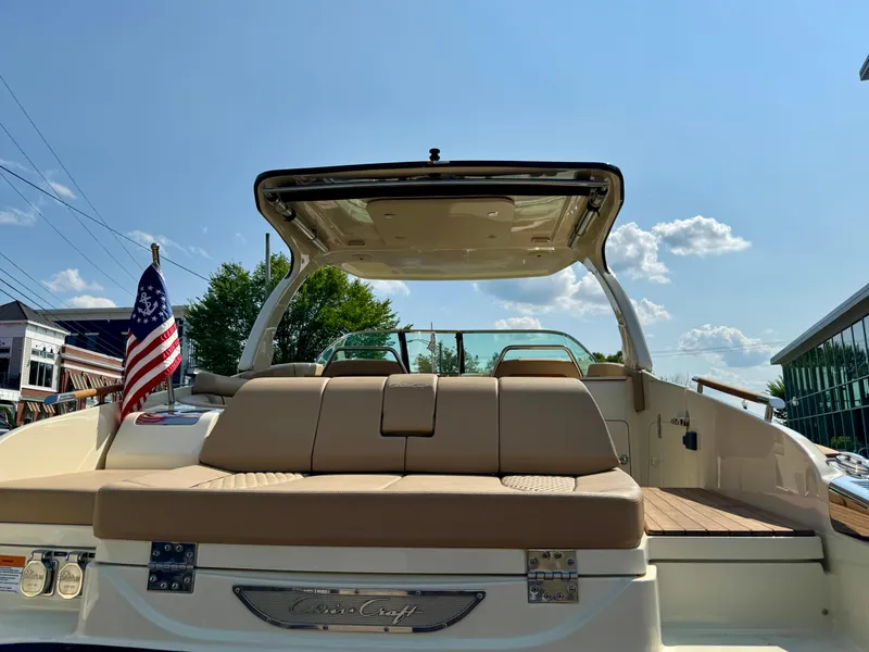 Slide: The Image of 2021 Chris-Craft Launch 35 GT boat with American flag, rear view, sunny day. - 29