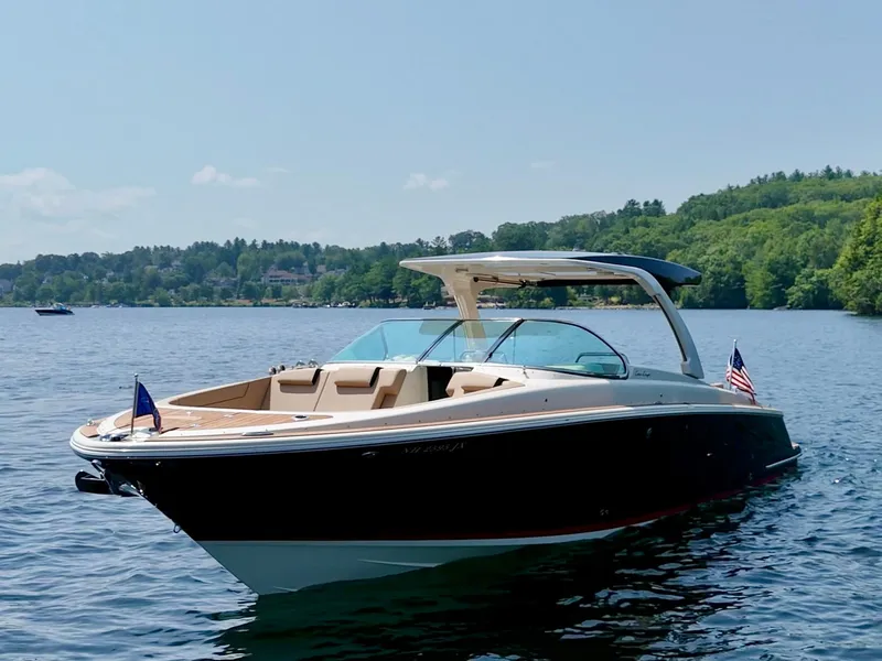 Slide: The Image of 2021 Chris-Craft Launch 35 GT boat on a serene lake with lush green shoreline. - 3