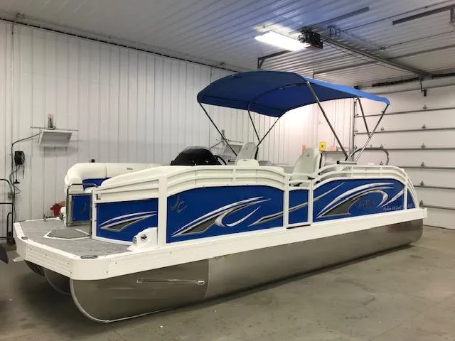 Slide: The Image of 2024 JC Neptoon 23 TT DSL pontoon boat in a garage. - 1