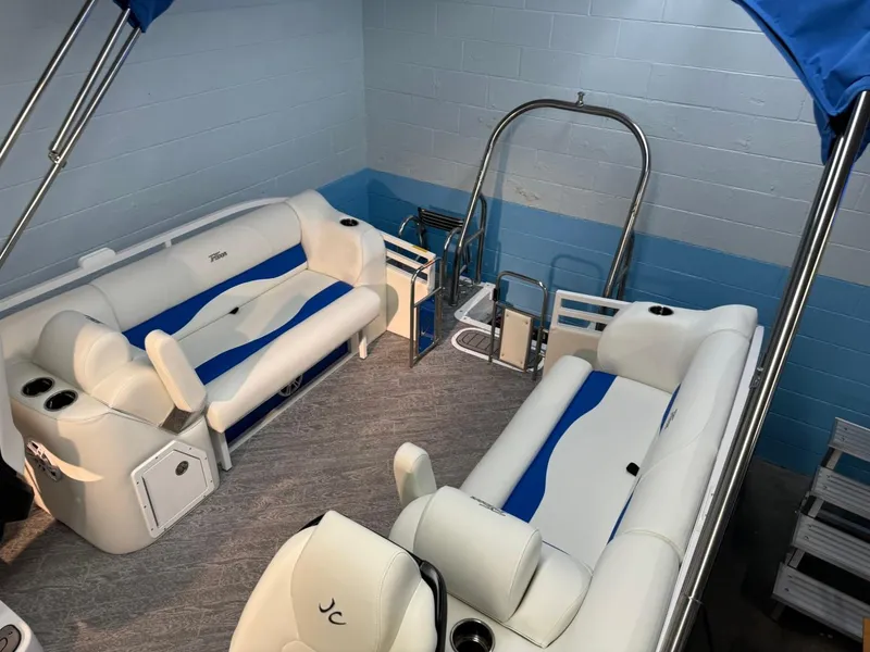 Slide: The Image of 2024 JC Neptoon 23 TT DSL pontoon boat interior with white and blue seating. - 11