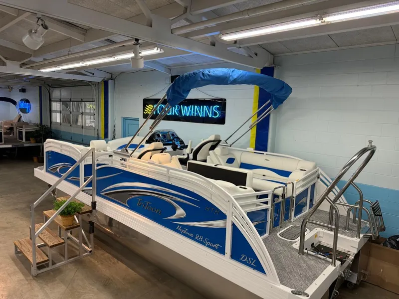 Slide: The Image of 2024 JC Neptoon 23 TT DSL pontoon boat in showroom with blue canopy. - 16