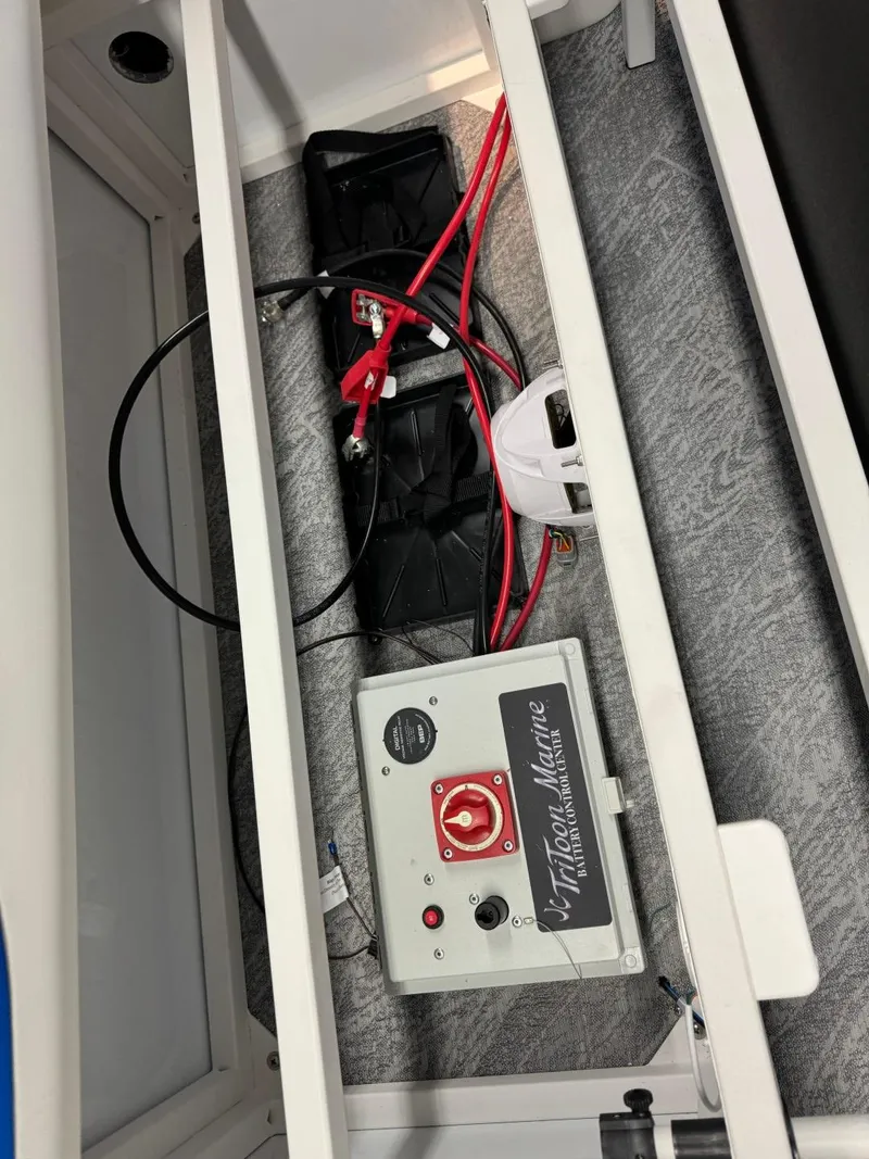 Slide: The Image of 2024 JC Neptoon 23 TT DSL boat battery compartment with wiring and control panel. - 24