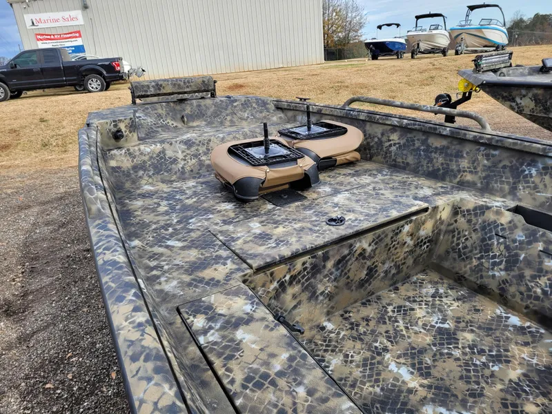 Slide: The Image of 2025 Excel 1651 River Warrior boat with camouflage design, parked outdoors. - 5