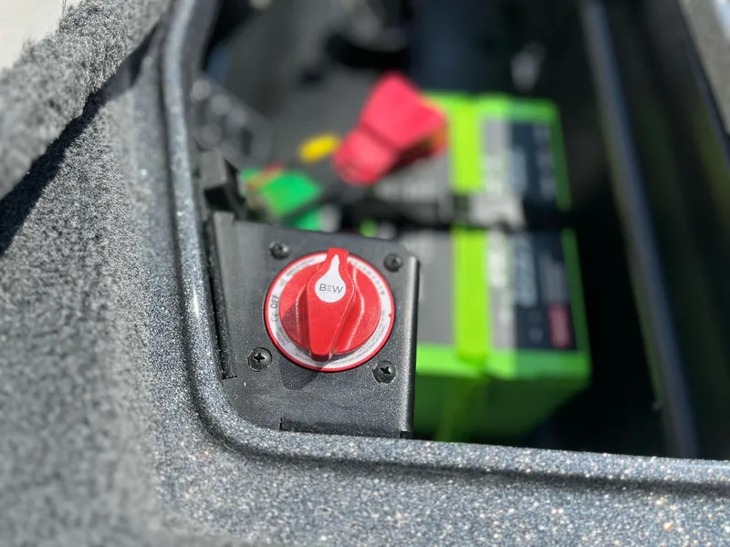 Slide: The Image of 2024 Ranger Z521R battery compartment with red switch and green battery. - 14
