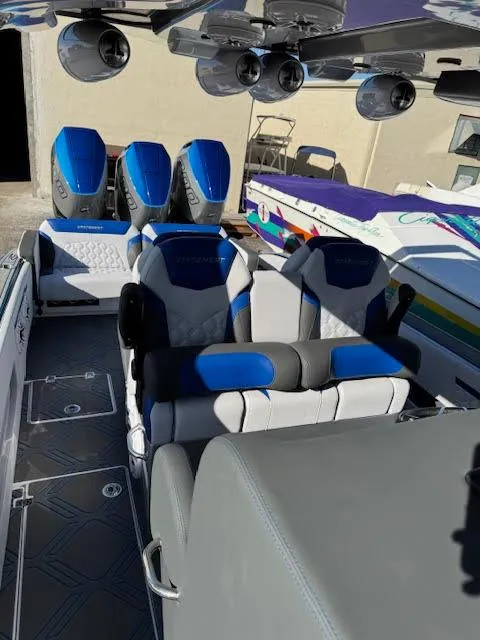 Slide: The Image of 2025 Statement 380 Open boat interior with blue and gray seating, triple engines. - 12