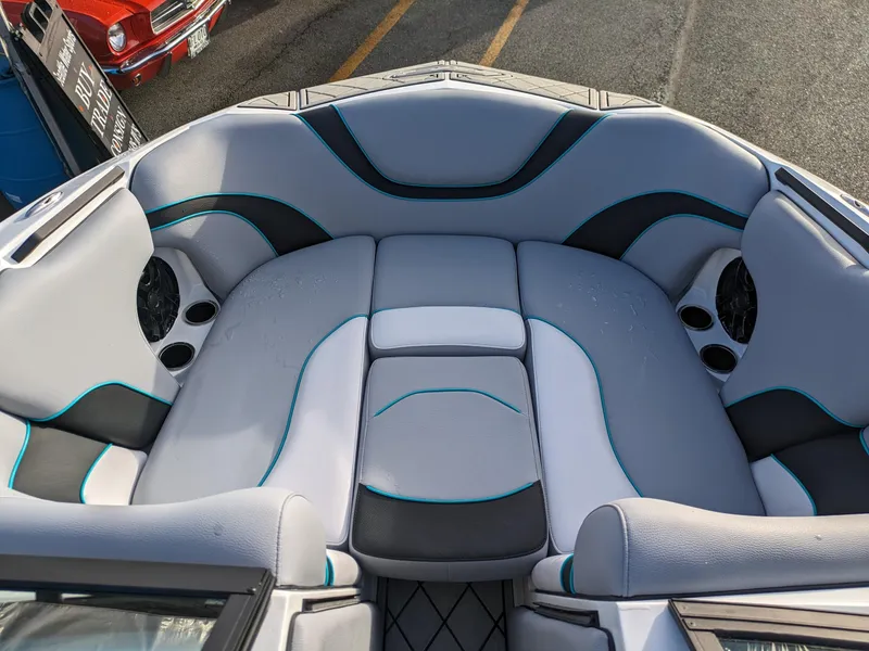 Slide: The Image of 2025 MB B52-23 Alpha boat interior with gray and black seating, cup holders, and speakers. - 15